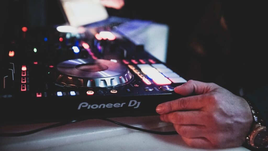 a person holding a dj controller in their hand