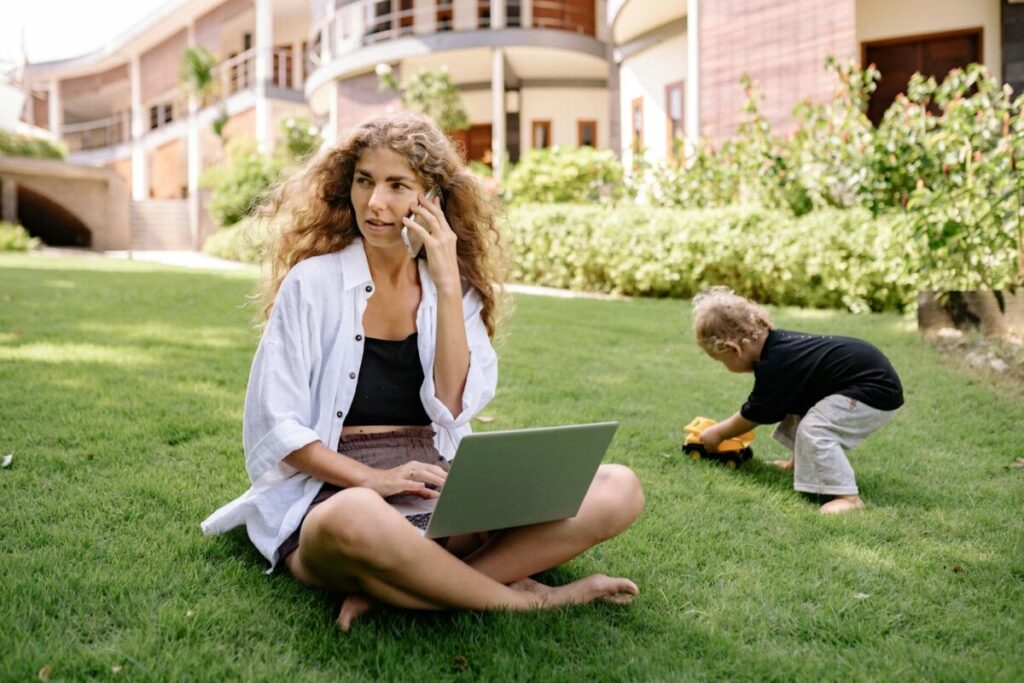 Word je gebeld door +31207910072? Ontdek wat er echt achter dit nummer zit Woman multitasking on phone and laptop while child plays outdoors.