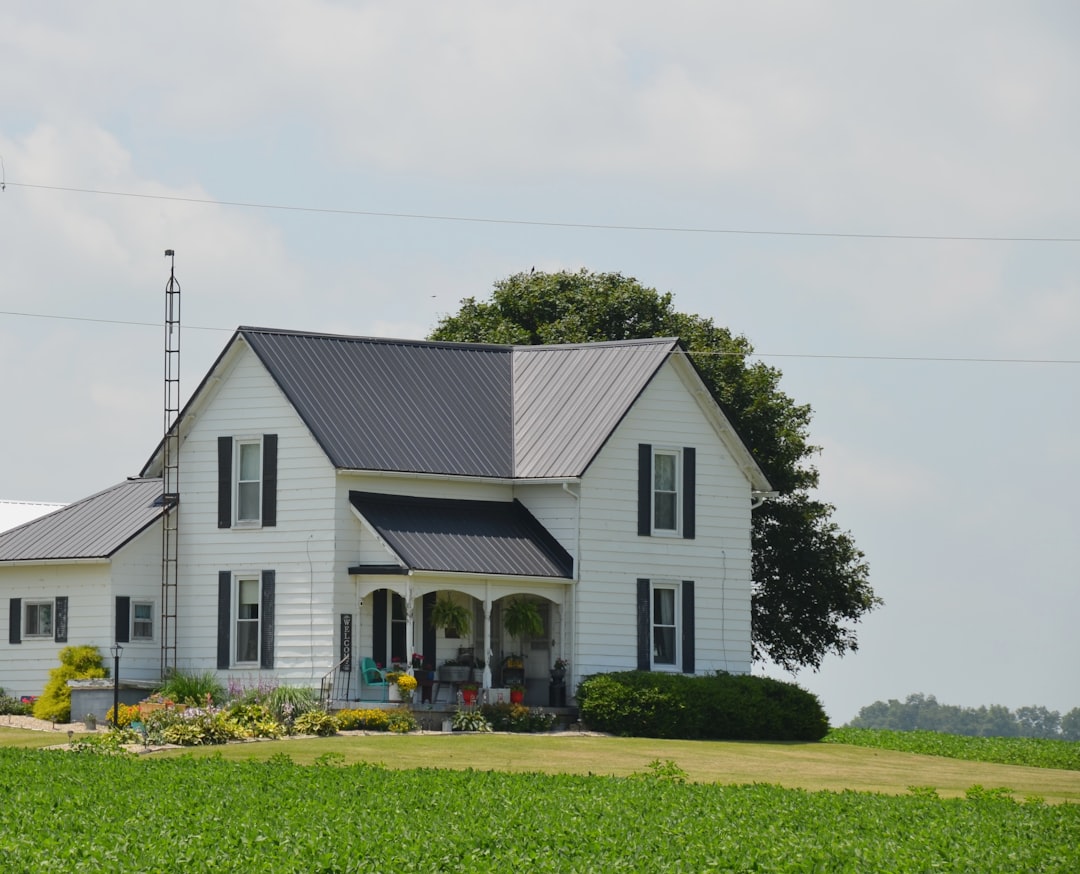 Older black and white 2 story frame farmhouse with porch